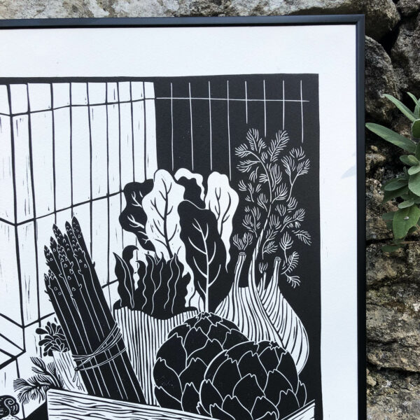 impression de linogravure en noir et blanc représentant des légumes de saison de printemps dans une cagette en bois, comme des asperges, artichauts, fenouil, blettes, fèves